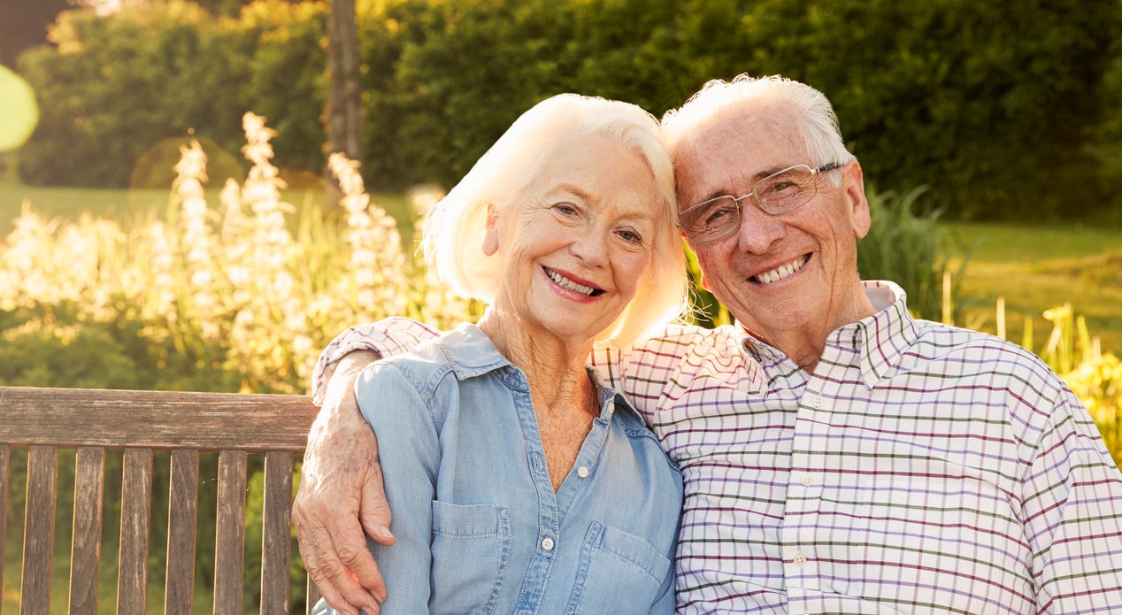 Das glückliche Ehepaar sitzt auf einer Bank